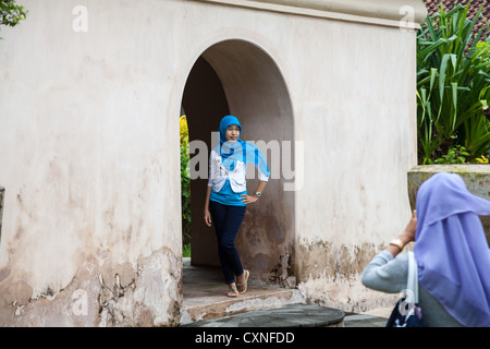 Le ragazze di scattare una foto nel castello d'acqua a Yogyakarta in Indonesia Foto Stock