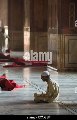 Giovane uomo che prega dentro la Jama Masjid principale moschea, la Vecchia Delhi, India Foto Stock