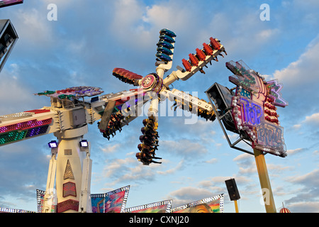 Persone a cavallo sulla sommità Buzz fairground ride a Nottingham storico Fiera d'oca. Foto Stock