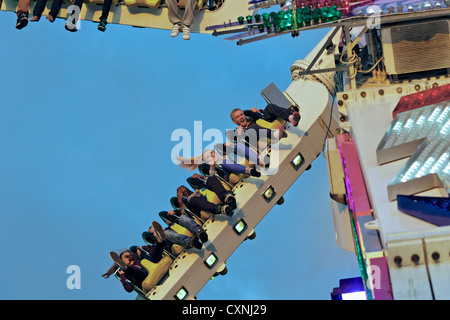 Persone a cavallo sulla sommità Buzz fairground ride a Nottingham storico Fiera d'oca. Foto Stock