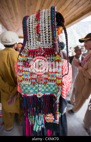 Kalash donna che indossa un cowrie guscio copricapo (shushut) presso il Joshi (Festa della Primavera), Rumbur Valley, biglietto, Khyber-Pakhtunkhwa, Pakistan Foto Stock