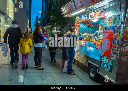New York, NY, USA, Street food, Scenes, uomini cinesi che comprano cibo da asporto da Street Vendor, Fifth Avenue, 59th Street, Dusk, Manhattan, food truck di New York Foto Stock
