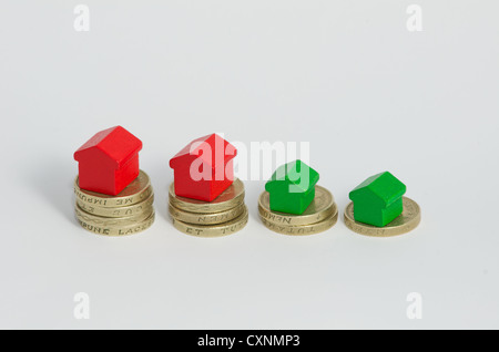 Pile di british una libbra di monete con monopolio casa di stile isolato su sfondo bianco Foto Stock