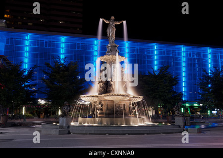 Tyler Davidson genio della fontana in Piazza Fontana, Cincinnati di notte con illuminazione blu building Foto Stock
