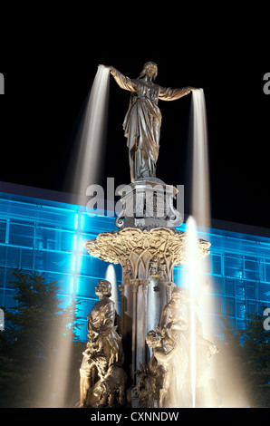 Tyler Davidson genio della fontana in Piazza Fontana, Cincinnati di notte con illuminazione blu building Foto Stock