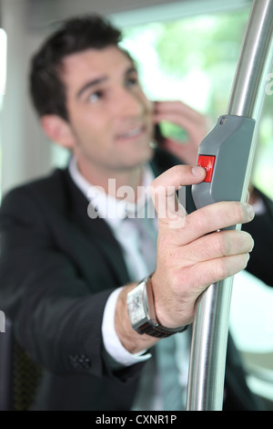 Imprenditore premendo il pulsante sul bus Foto Stock