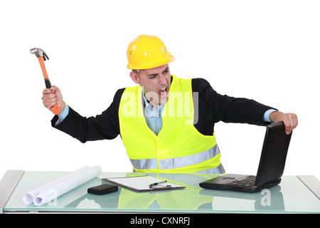 Architetto smashing il suo portatile con il martello Foto Stock