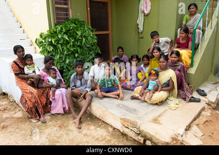 Un gruppo di abitanti di un villaggio indiano seduto fuori un indiano in casa rurale di un villaggio indiano. Andhra Pradesh, India Foto Stock