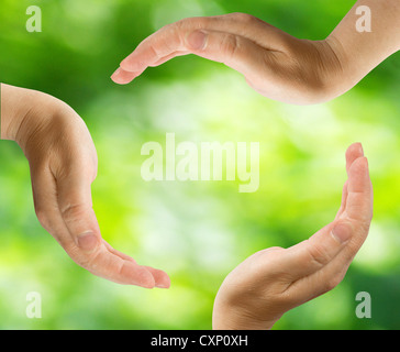 Simbolo di riciclaggio realizzato da mani su verde Foto Stock