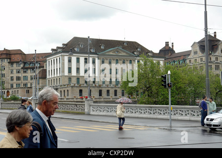 Persone, tra cui un paio, attraversando il ponte sul fiume Limmat a Zurigo. Essa aveva recentemente piovuto così le persone intorno erano meno. Foto Stock