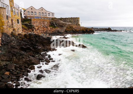 St Ives Cornwall costa frastagliata con onde che si infrangono contro gli scogli Foto Stock