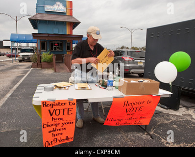Maschio bianco elettore volontario del cancelliere imposta la tabella di registrazione di Austin, TX, shopping center Parcheggio prima della prossima elezione. Foto Stock