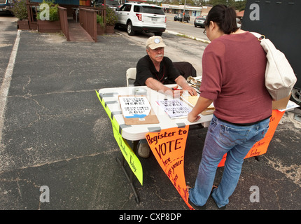 Maschio bianco elettore volontario del cancelliere imposta la tabella di registrazione di Austin, TX, shopping center Parcheggio prima della prossima elezione. Foto Stock