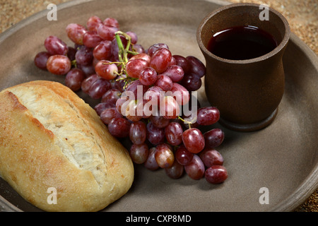 Vassoio con pane, uve rosse e bicchiere di vino che simboleggia il corpo e sangue di Cristo Foto Stock