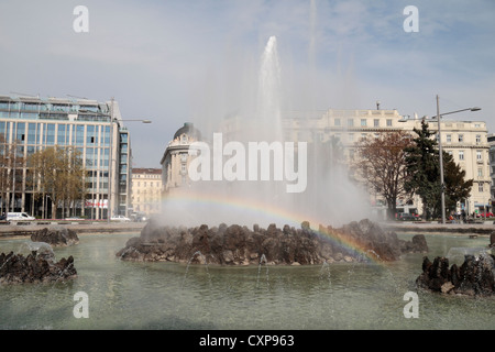 Un arcobaleno è formata in una fine nebbia del Hochstrahlbrunnen (alta fontana jet) in Schwarzenbergplatz, Vienna, Austria. Foto Stock