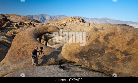 Fotografo in piedi accanto alla Alabama Hills Arch, Lone Pine, California, Stati Uniti d'America Foto Stock