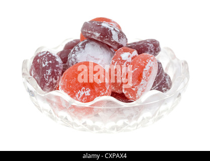 Un piccolo piatto di vetro riempito con frutta aromatizzati hard candy spolverato con zucchero a velo. Foto Stock