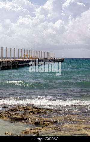 Un lungo molo andando fuori nell'oceano tropicale Foto Stock