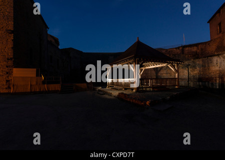 Sedan, Francia. Un antico pozzo di notte nel cortile del Le Chateau Fort Hotel. Foto Stock