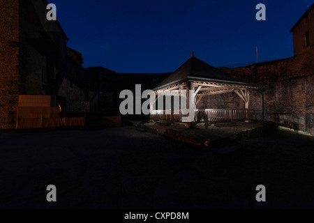 Sedan, Francia. Un antico pozzo di notte nel cortile del Le Chateau Fort Hotel. Foto Stock