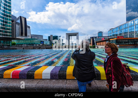 Parigi. Una coppia al quartiere finanziario La Defense. In background: una piscina, il grande arco e edifici di uffici. Foto Stock