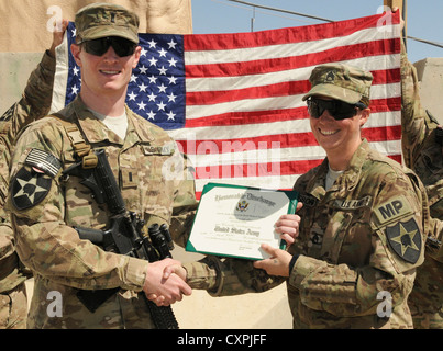 Il personale sgt. rebecca osborn, una polizia militare soldato da daggett, mich., compare dopo reenlisting nell'esercito durante una cerimonia a inoltrare una base operativa spin boldak, Afghanistan, oct. 7, 2012. osburn è attaccata alla seconda divisione di fanteria del quinto battaglione, ventesimo reggimento di fanteria. Il 5-20th fanteria è parte della terza stryker brigade combat team dal giunto di base di lewis mcchord, wash. Foto Stock