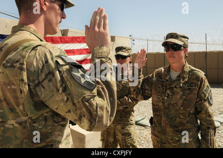 Il personale sgt. rebecca osborn, una polizia militare soldato da daggett, mich., reenlists nell'esercito durante una cerimonia a inoltrare una base operativa spin boldak, Afghanistan, oct. 7, 2012. osburn è attaccata alla seconda divisione di fanteria del quinto battaglione, ventesimo reggimento di fanteria. Il 5-20th fanteria è parte della terza stryker brigade combat team dal giunto di base di lewis mcchord, wash. Foto Stock