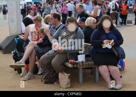 Obesi l uomo e la donna a mangiare cibo spazzatura. Londra. In Inghilterra. Regno Unito. Soggetti volto riconoscibile oscurati. Foto Stock