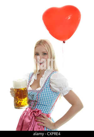 Donna in Dirndl con cuore palloncino e boccale di birra Foto Stock