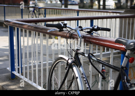 Due cicli concatenati per ringhiere sul terrapieno a Londra Foto Stock