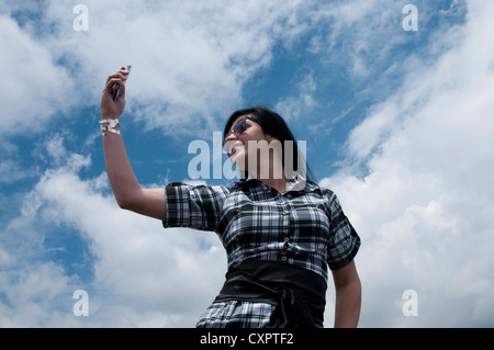 Una giovane donna latina parlando al telefono cellulare Foto Stock