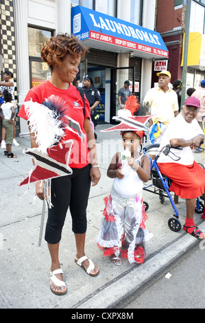 U.S.A.: Brooklyn, New York. Ragazza in rappresentanza di Trinidad e Tobago e la sua mamma per prendersi una pausa durante i Caraibi Kiddies parata del giorno. Foto Stock