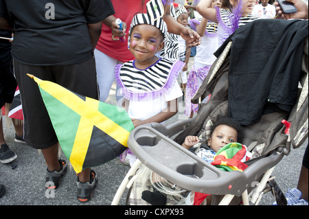 Caraibi Kiddies parata del giorno, Crown Heights. Costume, ragazza giovane azienda bandiera giamaicana. I l corteo è parte della giornata del lavoro eventi. Foto Stock