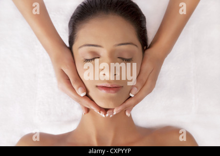 Giovane donna con il massaggio del viso Foto Stock