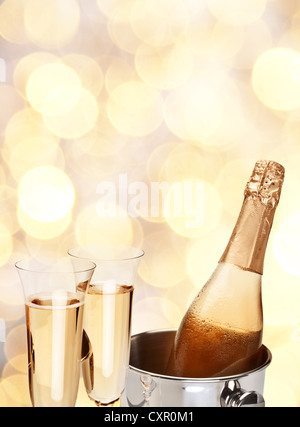 Due bicchiere di champagne con bottiglia in un giallo la sfocatura dello sfondo. Foto Stock