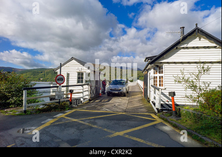 Auto pagare pedaggi carica dopo attraversamento di vecchio legno stretto ponte che attraversa il fiume mawddach, rhinog montagne sullo sfondo, New Scenic 5 posti Foto Stock