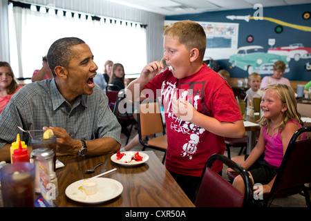 Il Presidente Usa Barack Obama condivide la sua torta alle fragole con un ragazzo durante una sosta per il pranzo in corrispondenza di angoli Kozy ristorante Luglio 5, 2012 in Oak Harbor, Ohio. Foto Stock