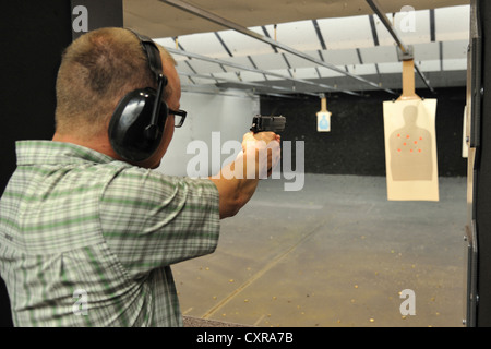 Sparatutto maschio pistola di puntamento durante la pratica di targeting al poligono di tiro, Colorado, STATI UNITI D'AMERICA Foto Stock