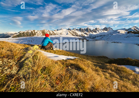 Donna che guarda verso la montagna Kalkkoegel, lago Salfainssee, Axamer Lizum, Nord Tirolo Tirolo, Austria, Europa Foto Stock