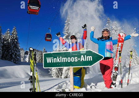 Gli sciatori con segno 'Winklmoos-Alm' e seggiovia o funivia, Reit im Winkl, regione Chiemgau, Baviera, Germania, Europa Foto Stock