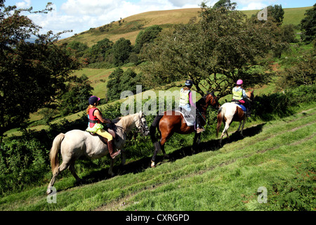 Le tre ragazze o giovani donne a cavallo lungo un percorso nei pressi di Moel Arthur nel Galles del Nord Foto Stock