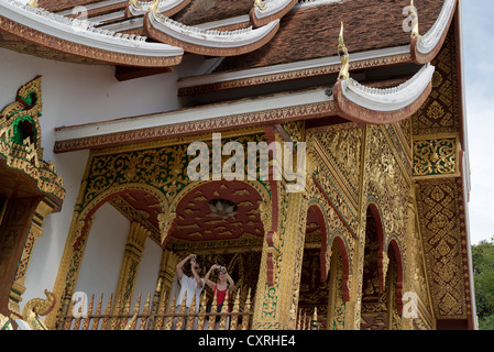 I turisti scattare foto da un tempio nei giardini del Palazzo Reale a Luang Prabang, Laos Foto Stock