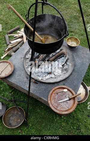 La cottura di pit al field camp di legionari, con paiolo di rame o pentola, Festival Romano, il Parco Archeologico Xanten Foto Stock