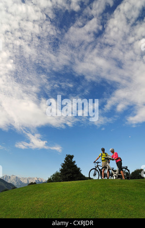 Un paio di equitazione biciclette elettriche, montagna Wilder Kaiser sul retro, Reit im Winkl, Chiemgau, Alta Baviera, Baviera Foto Stock