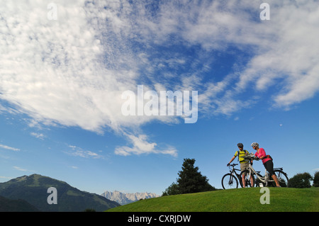 Un paio di equitazione biciclette elettriche, montagna Wilder Kaiser sul retro, Reit im Winkl, Chiemgau, Alta Baviera, Baviera Foto Stock