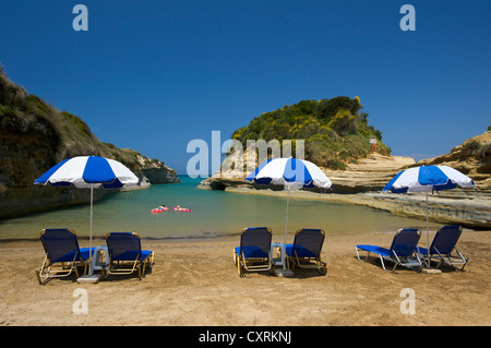 Sedie a sdraio e ombrelloni sulla spiaggia, Canal d'Amour, vicino a Sidari, Corfu, Isole Ionie, Grecia, Europa Foto Stock