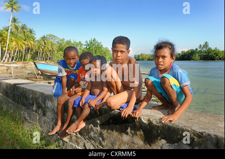 I bambini di Papua nella parte anteriore di una laguna, isola di Biak, fuori dell'isola di Papua Nuova Guinea, Indonesia Asia sud-orientale, Asia Foto Stock