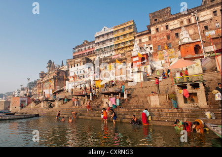 I bagnanti, barche, Ghats, santo scale che portano al Gange, vista città nelle prime ore del mattino, Varanasi, Benares o Kashi Foto Stock