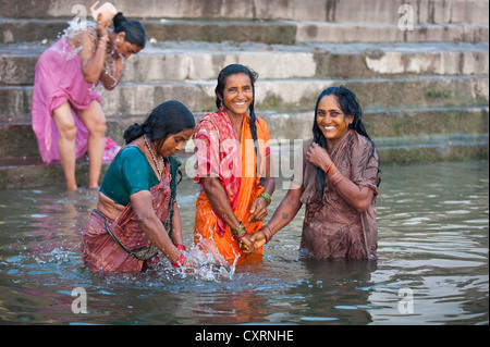 Donna sorridente facendo il bagno nel Gange, Ghats, Varanasi, Benares o Kashi, Uttar Pradesh, India, Asia Foto Stock