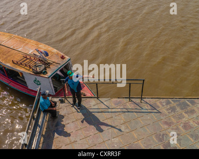 Due uomini, visto dal di sopra, parlare e gesto presso il fiume porta dock pubblica in Asunción, Paraguay. Foto Stock